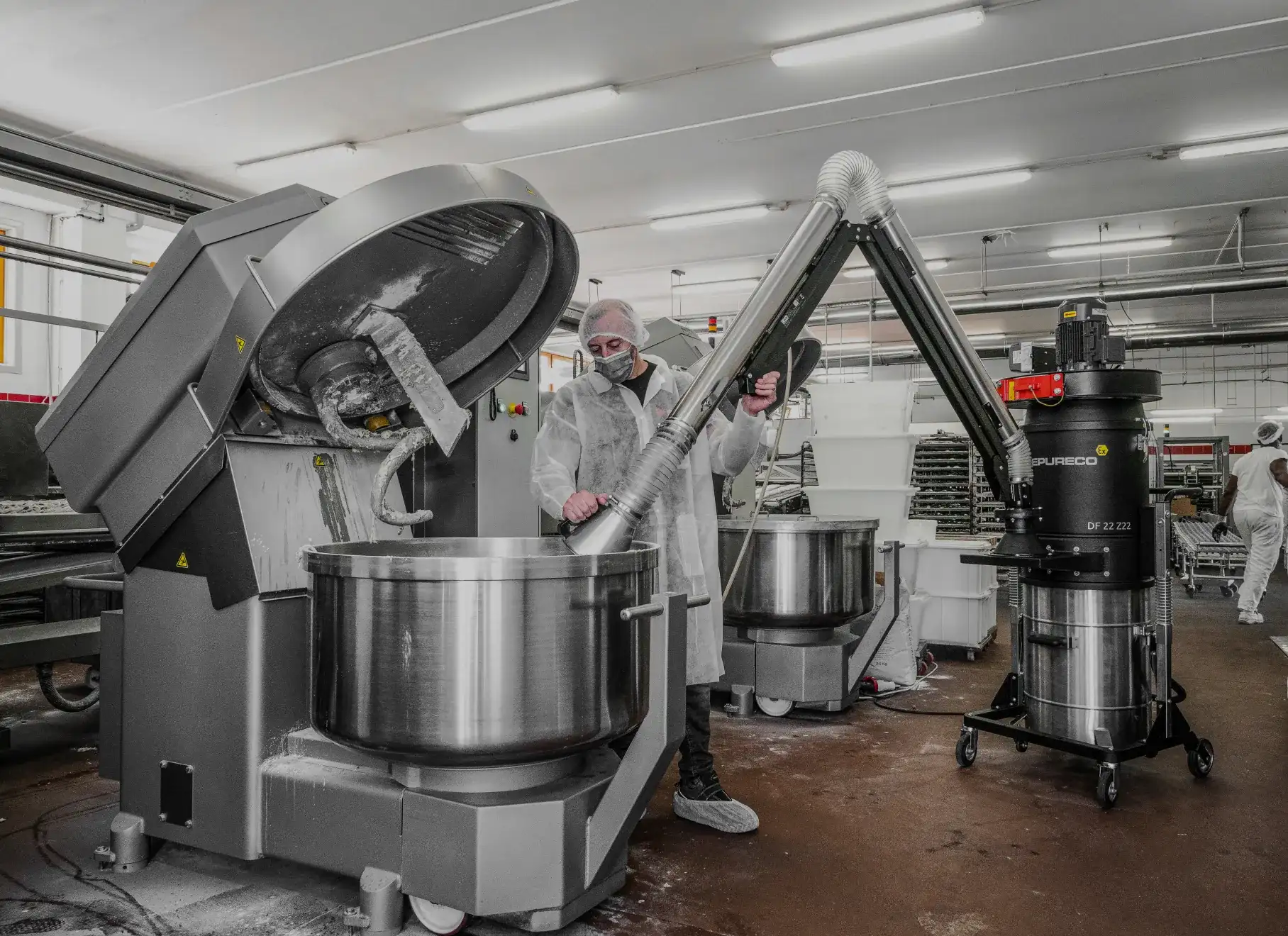 Operator using an industrial vacuum in a hazardous-area environment